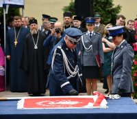 Komendant Wojewódzki Policji wbija gwóźdź honorowy do sztandaru.
