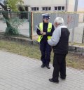 Policjantka z Wydziału Ruchu Drogowego wręcza odblask mężczyźnie