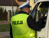 Policjant Wydziału Ruchu Drogowego bada stan trzeźwości kierowcy pojazdu