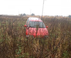 Volkswagen Passat koloru czerwonego pozostawiony na polu
