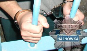 Ręce, na których założone są kajdanki trzymają kratę, w prawym dolnym rogu gwiazda policyjna z napisem Hajnówka