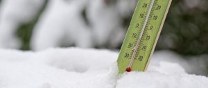 Zdjęcie przedstawia termometr umieszczony na śniegu.