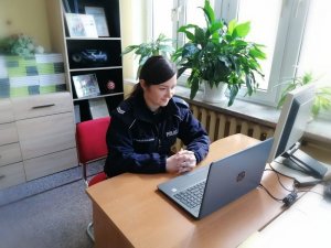 Zdjęcie przedstawia policjantkę, która uczestniczy w spotkaniu online.