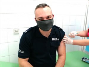 Komendant Powiatowy Policji w Hajnówce w trakcie szczepienia.