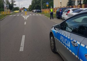 Zdjęcie przedstawia policjanta sprawdzającego rejon przejścia dla pieszych