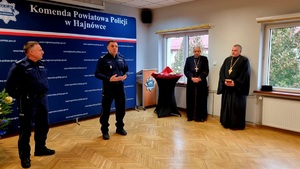 Zdjęcie przedstawia policjantów w umundurowaniu służbowym kolory granatowego, zgromadzonych w świetlicy przy wigiljnym stole.