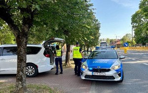 w tle radiowóz, policjanci i pojazd osobowy