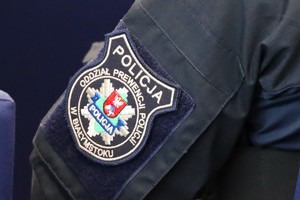 Ramę policjanta ubranego w mundur, z emblematem Oddziału Prewencji Policji w Białymstoku