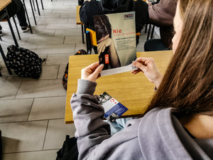Uczennica czytająca ulotkę dotyczącą handlu ludźmi.